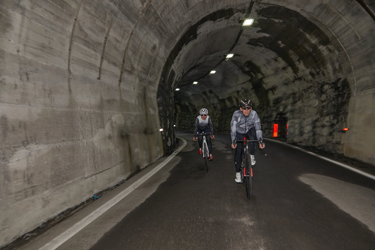 Two riders coming out of a mountain tunnel